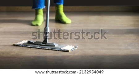 Cropped close up image of barefoot young woman in casual clothes washing heated wooden laminate warm floor using microfiber wet mop pad, doing homework cleaning routine, housekeeping job concept
 Foto stock © 