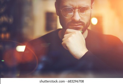 Cropped close up image of pensive bearded entrepreneur in optical spectacles for better views dressed in black sweatshirt.Pondering businessman in trendy eyeglasses thinking on blurred background - Shutterstock ID 683296708