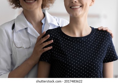 Cropped Close Up Image Smiling Kind Compassionate Young Female Oncologist Doctor Cuddling Shoulders Of Happy Patient With Cancer Disease, Giving Psychological Help And Support At Checkup Meeting.