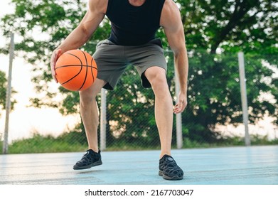 Cropped close up muscular young sporty sportsman man 20s wear black sports clothes training basketball ball handling drills play at basketball game playground court Outdoor courtyard sport concept - Powered by Shutterstock