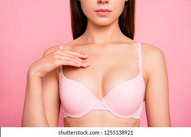 Cropped close up photo of pretty cute with perfect soft skin she her woman with hand ribbing cream in cleavage zone wearing pale pink bra isolated on rose background