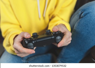 Cropped and close up photo youth girl with arcade joystick in hands sitting on comfort couch. She spending free time playing in funny online games - Powered by Shutterstock