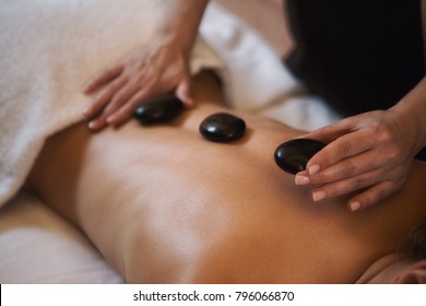 Cropped Close Up Of A Professional Therapist Masseuse Doing Hot Stones Massage Her Female Client Service Relaxation Therapy Treatment Healthy Spa Wellbeing Wellness Recreation Hotel Resort