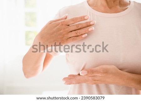 Cropped close up shot of caucasian woman doing palpation of her breast for prevention breast cancer. Self-checking medicine for female. World cancer day