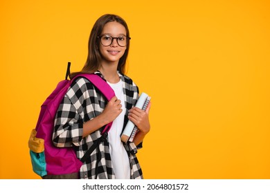 Cropped close up shot of a happy smart caucasian teenager schoolgirl pupil student wearing bag going back to school for new academic educational year isolated in yellow background