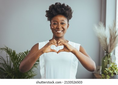 Cropped close up smiling grateful woman showing heart sign, gesture, expressing love and care, happy thankful young female volunteer supporting sick people, regular medical checkup promotion - Shutterstock ID 2133526503