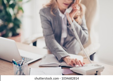 Cropped closeup photo of clever smart professional polite secretary in grey formal suit is calling to her boss, she is sitting at the table in office - Shutterstock ID 1034682814
