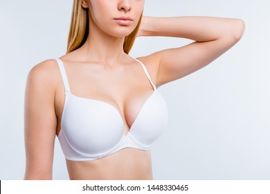 Cropped close-up portrait of nice calm confident attractive lovely blonde girl chest after uplift injection wearing bra touching hair isolated over light gray background