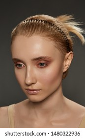 Cropped Close-up Shot Of A Young Blonde European Girl With A Black Hairband In The Form Of A Spiral Spring In Her Hair. The Fashion Model With Nude Make-up Is Looking Away, 