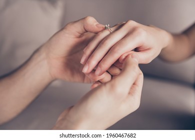 Cropped close-up view of hands girl receiving ring from guy fiance propose moment finger at home indoors