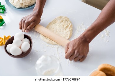 Cropped close-up view of his he guy hands making fresh handmade bread pizza pie cake rolling dough bakehouse craft on table desktop using pin in modern light white interior house kitchen - Powered by Shutterstock