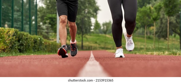 Cropped down view of athletic mother and son jogging or running on running track in green park. Woman and boy wearing sportswear. Modern healthy and sports lifestyle. Family spending time together - Powered by Shutterstock