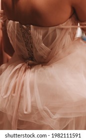 Cropped Figure Of A Woman Dressed In A Puffy Wedding Dress. Back View