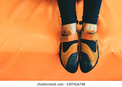 Cropped Frame Of Female Foot In Climbing Shoes In Bouldering Gym.