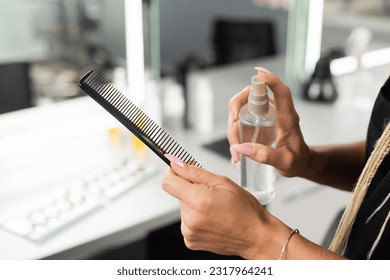 cropped, hairdresser disinfecting hair comb, holding spray bottle, hair professional, salon work, cleaning salon tools, sterilization, salon hygiene, barber shop, beauty, cleanliness, small business - Powered by Shutterstock