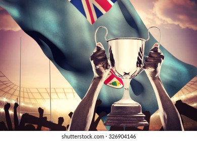 Cropped hand of athlete holding trophy against rugby stadium - Powered by Shutterstock