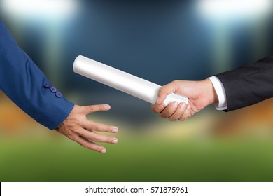 Cropped hand of businessman passing relay baton to colleague, the concept of teamwork for business success