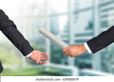 Cropped hand of businessman passing relay baton to colleague, the concept of teamwork for business success