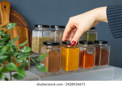 Cropped hand holding jar of spices on kitchen. - Powered by Shutterstock