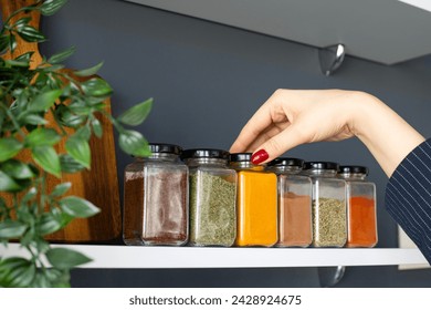 Cropped hand holding jar of spices on kitchen. - Powered by Shutterstock