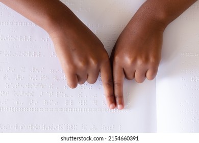 Cropped hands of african american elementary schoolgirl studying while touching braille book. unaltered, education, learning, studying, blindness, disability and school concept. - Powered by Shutterstock