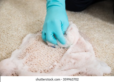 Cropped Hands Cleaning Rug With Foam At Home