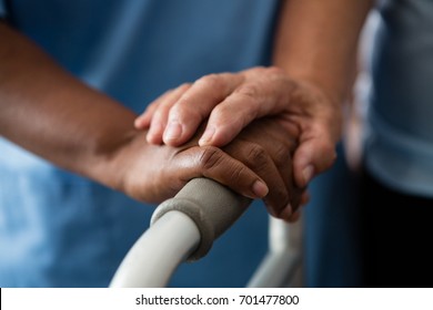 Cropped Hands Of Nurse And Senior Woman Holding Walker In Nursing Home