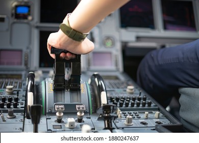 Cropped Hands Of Pilot Flying A Commercial Airplane, Cockpit View Close Up Of Hands. Captain Hand Accelerating On The Throttle In Commercial Airplane. Selective Focus.