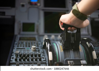 Cropped Hands Of Pilot Flying A Commercial Airplane, Cockpit View Close Up Of Hands. Captain Hand Accelerating On The Throttle In Commercial Airplane. Selective Focus.