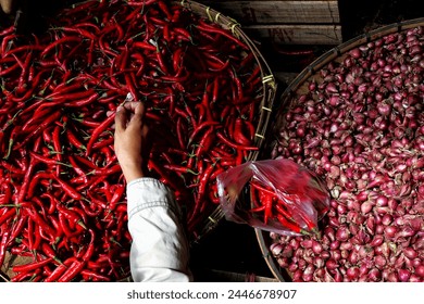 Cropped hands of woman buying red chili pepperrs for sale at market stall - Powered by Shutterstock