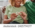 cropped and happy african american couple holding hearing aid device near boyfriend, accessibility