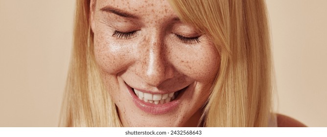 Cropped highly detailed shot of positive female with freckles. Close-up portrait of young woman with closed eyes and freckled skin over pastel backdrop. - Powered by Shutterstock