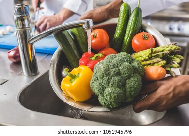 Cropped Image Of African American Chef Washing Vegetables At Restaurant Kitchen