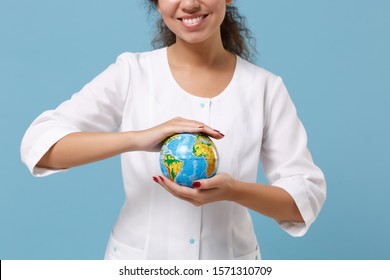 Cropped Image Of African American Doctor Woman Isolated On Blue Background. Female Doctor In Medical Gown Holding Earth World Globe. Healthcare Personnel Medicine Health Concept. Mock Up Copy Space