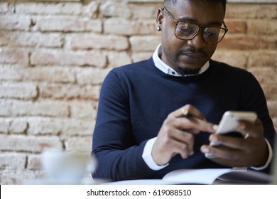 Cropped Image Of Afro American International Student In Spectacles Browsing Internet Websites On Smartphone In Searching Useful Languages Seminars For Studying Remote Using Free Wifi In Coffee Shop