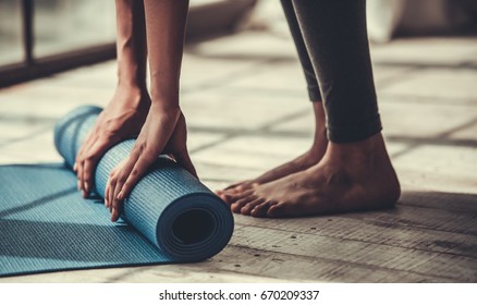 Cropped image of Afro American rolling yoga mat - Shutterstock ID 670209337