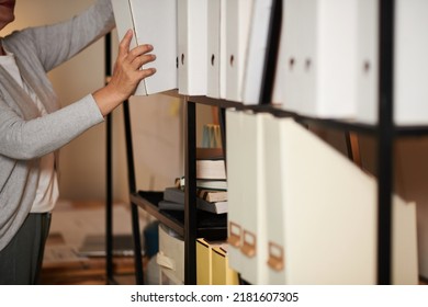 Cropped image of architect taking binder from shelf in bureau office - Shutterstock ID 2181607305