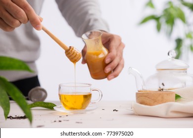 Cropped image of arista pouring honey into cup of tea - Powered by Shutterstock