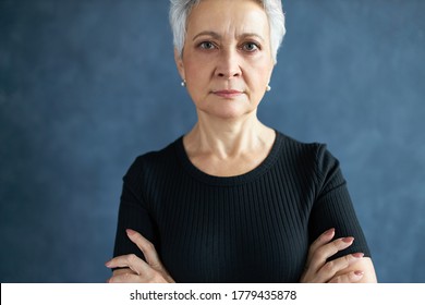 Cropped Image Of Attractive Middle Aged European Female With Stylish Short Haircut Having Strict Serious Facial Expression, Keeping Arms Folded In Closed Posture, Being Stubborn. Body Language