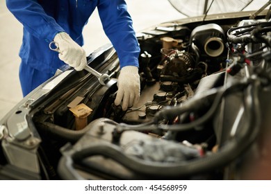Cropped image of auto mechanic checking car engine