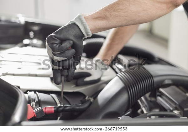 Cropped image of automobile mechanic repairing car\
in automobile store