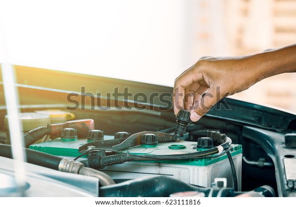 Cropped image of automobile mechanic repairing car\
in store, day time