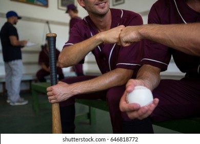 Cropped image of baseball players sitting on bench in locker room - Powered by Shutterstock