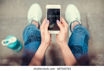 Cropped Image Of Beautiful Afro American Girl In Sportswear Using Timer On A Smart Phone For Morning Run