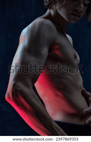Cropped image of beautiful male body, muscular torso, hands against dark studio background. Power, strength. Concept of men's beauty, health, body art and aesthetics, care, sportive lifestyle