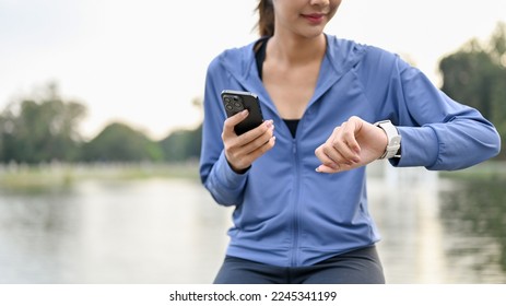 cropped image, Beautiful sporty Asian woman in sportswear checking her heart rate and running miles on her smartwatch. - Powered by Shutterstock