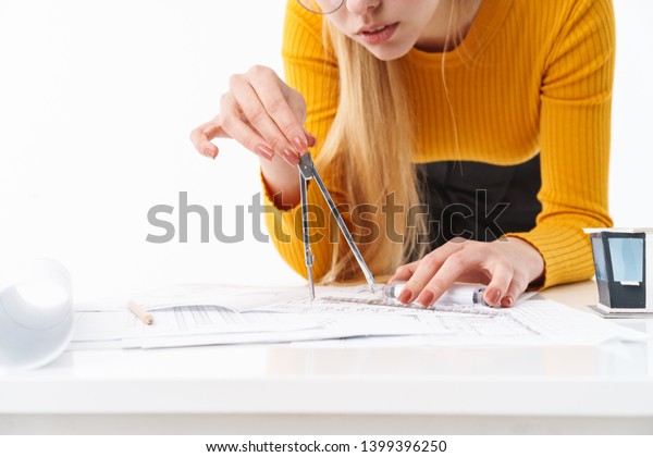 Cropped image of a beautiful young\
blonde woman architect standing isolated over white\
background