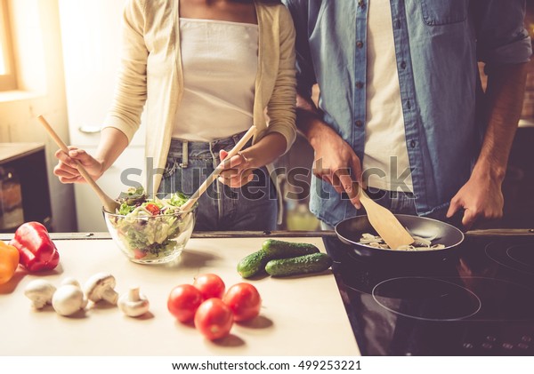 家庭の台所で調理する美しい若い夫婦のイメージを切り抜き の写真素材 今すぐ編集