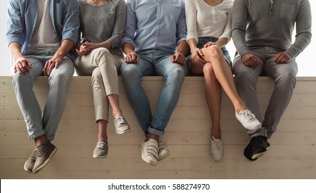 Cropped image of beautiful young people in casual clothes sitting together on the window sill - Shutterstock ID 588274970