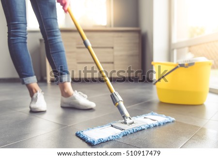 Cropped image of beautiful young woman in protective gloves using a flat wet-mop while cleaning floor in the house Imagine de stoc © 